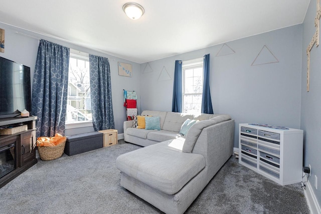 carpeted living room featuring baseboards and plenty of natural light
