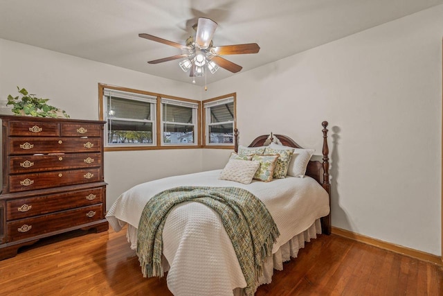 bedroom with baseboards, ceiling fan, and wood finished floors