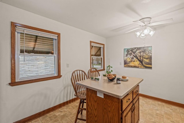 dining area featuring baseboards and ceiling fan
