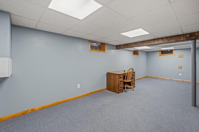 finished basement featuring carpet floors, baseboards, and a drop ceiling