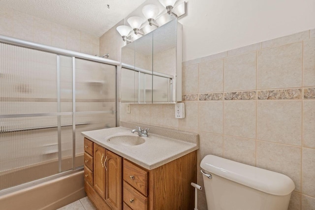 bathroom with enclosed tub / shower combo, toilet, tile walls, and vanity