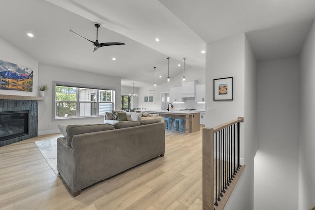 1205 Thistle Dew Ln, Waunakee, WI 53597 - living area featuring a ceiling fan, lofted ceiling, a fireplace, light wood-style flooring, and recessed lighting