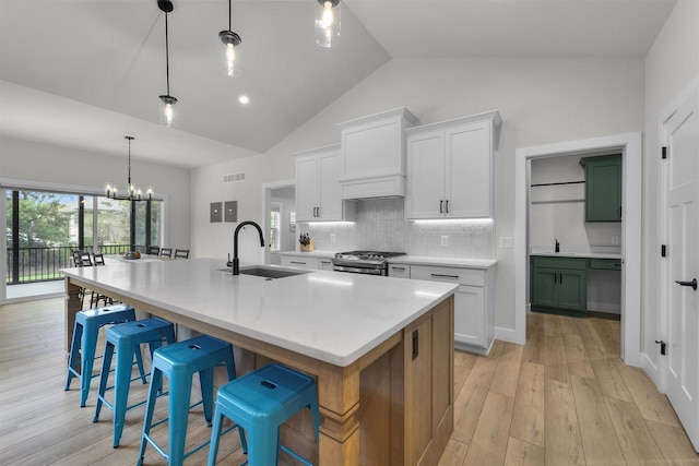 1205 Thistle Dew Ln, Waunakee, WI 53597 - kitchen with a sink, stainless steel range with gas cooktop, backsplash, a chandelier, and a spacious island