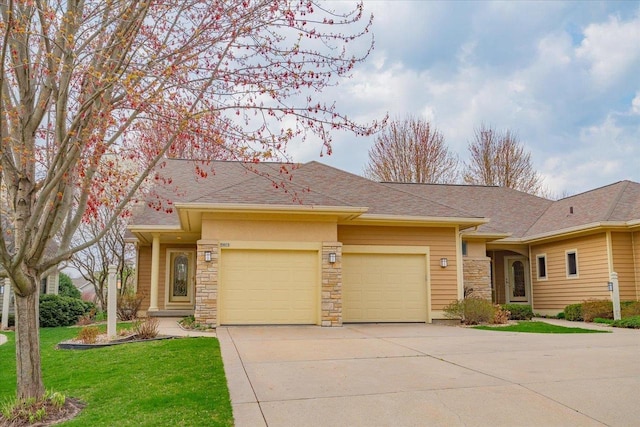 view of front of property featuring an attached garage, a front yard, stone siding, and concrete driveway