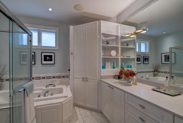 full bath featuring tile patterned flooring, a wealth of natural light, a bath, and vanity