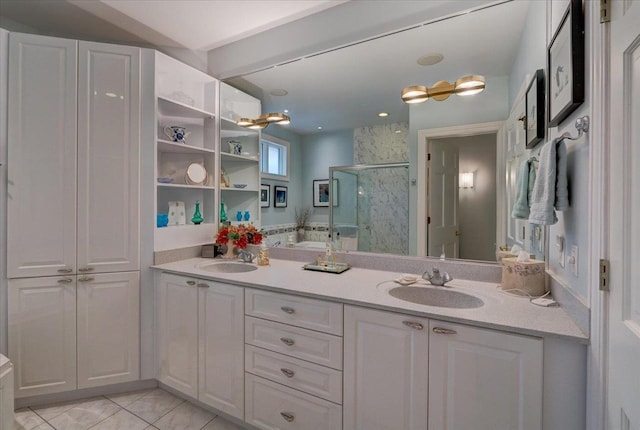 bathroom with double vanity, a shower stall, a sink, and a garden tub