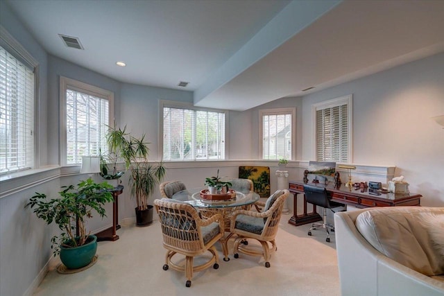carpeted dining space with baseboards, plenty of natural light, and visible vents