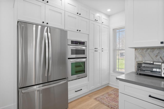 397 W Geneva St, Williams Bay, WI 53191 - kitchen featuring appliances with stainless steel finishes, light wood-type flooring, a toaster, white cabinets, and recessed lighting