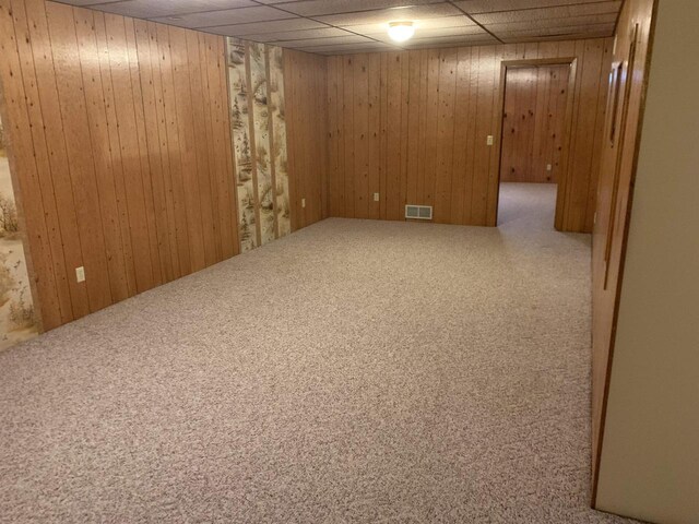 312 W Buehler Ave, Nekoosa, WI 54457 - finished below grade area with visible vents, carpet flooring, and wooden walls