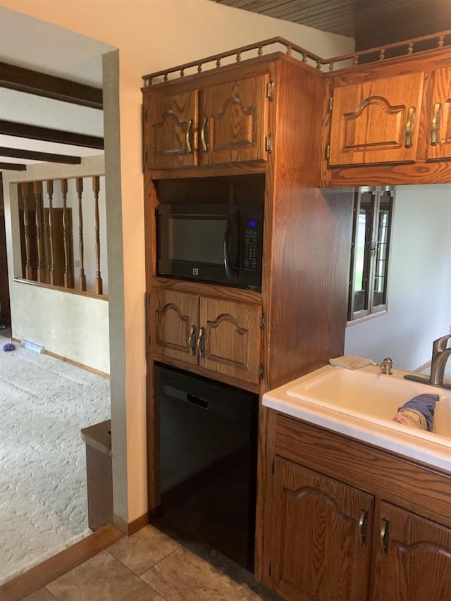 312 W Buehler Ave, Nekoosa, WI 54457 - kitchen featuring tile patterned flooring, brown cabinets, a sink, light countertops, and black appliances
