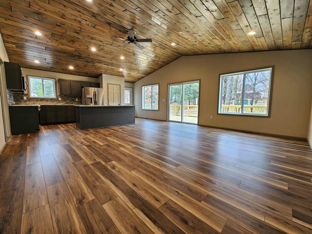 1093 W Queens Way, Nekoosa, WI 54457 - unfurnished living room featuring vaulted ceiling, wooden ceiling, a ceiling fan, and dark wood finished floors