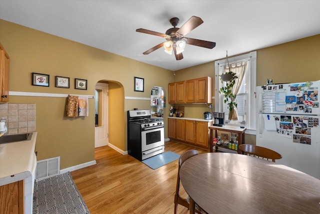 1932 N Warren Ave Unit 1934, Milwaukee, WI 53202 - kitchen featuring ceiling fan, visible vents, arched walkways, stainless steel gas range oven, and freestanding refrigerator