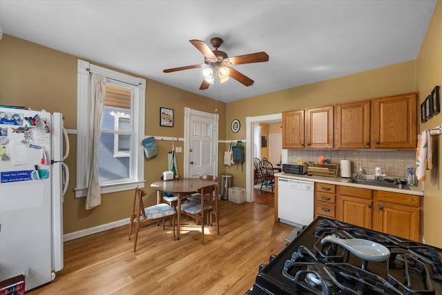 1932 N Warren Ave Unit 1934, Milwaukee, WI 53202 - kitchen featuring ceiling fan, a sink, light wood-style floors, white appliances, and decorative backsplash
