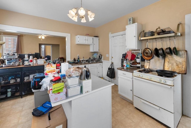 1932 N Warren Ave Unit 1934, Milwaukee, WI 53202 - kitchen featuring pendant lighting, gas range gas stove, a sink, ceiling fan with notable chandelier, and white cabinetry