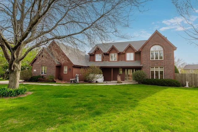 traditional home featuring fence, roof with shingles, a porch, and a front lawn