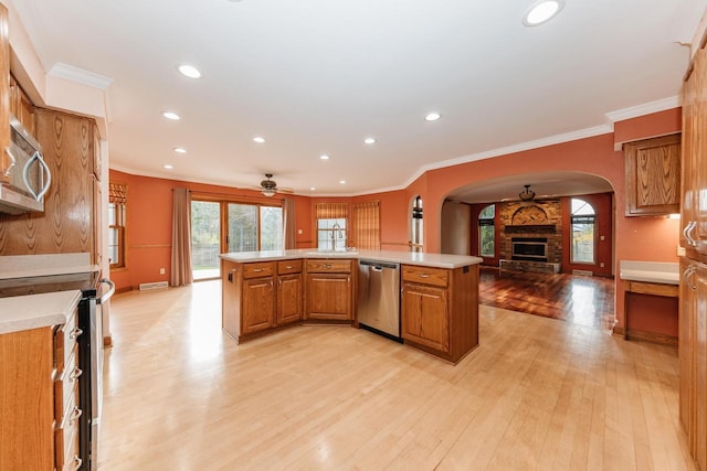kitchen featuring open floor plan, ceiling fan, light countertops, arched walkways, and appliances with stainless steel finishes