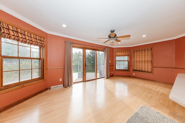 unfurnished living room with visible vents, ornamental molding, baseboards, a ceiling fan, and light wood finished floors
