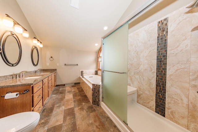 bathroom with double vanity, a sink, a bath, and toilet