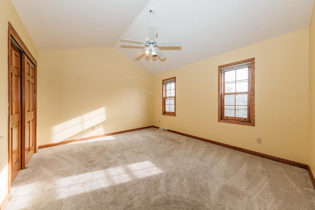 unfurnished bedroom featuring carpet floors, baseboards, a ceiling fan, and vaulted ceiling