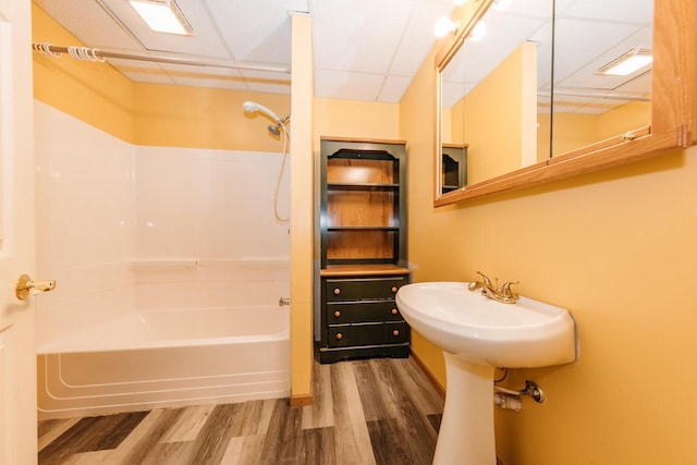 bathroom with a paneled ceiling, shower / tub combination, and wood finished floors