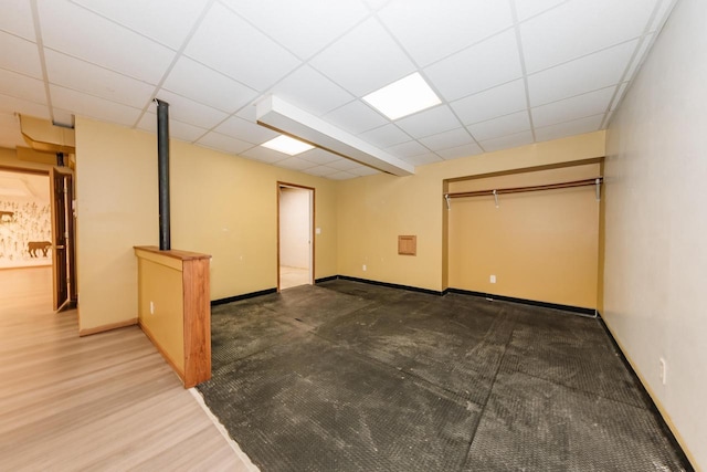 finished basement featuring baseboards and a drop ceiling