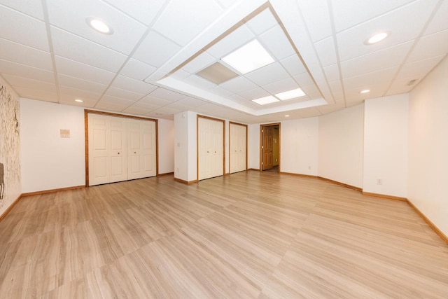 spare room with baseboards, a drop ceiling, recessed lighting, and light wood-style flooring