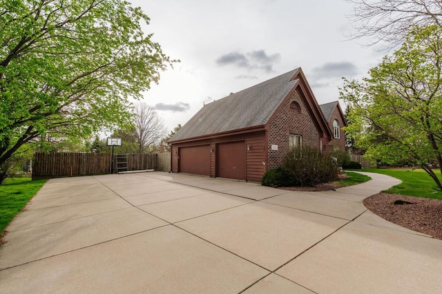 view of property exterior with brick siding, fence, and roof with shingles