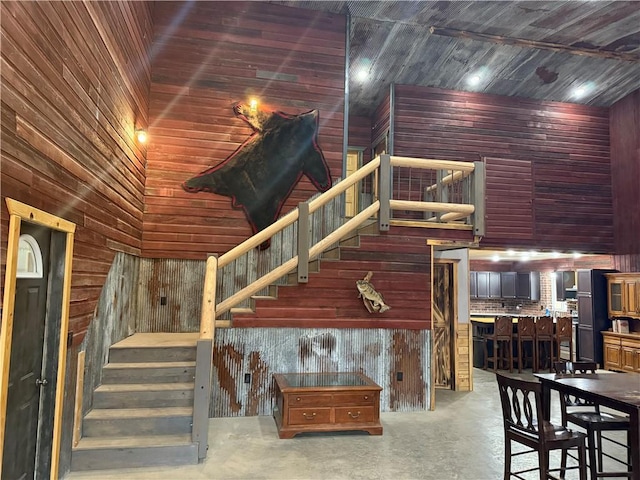 8523 Lakeside Rd, Trego, WI 54888 - stairway featuring a high ceiling, wood walls, and concrete floors