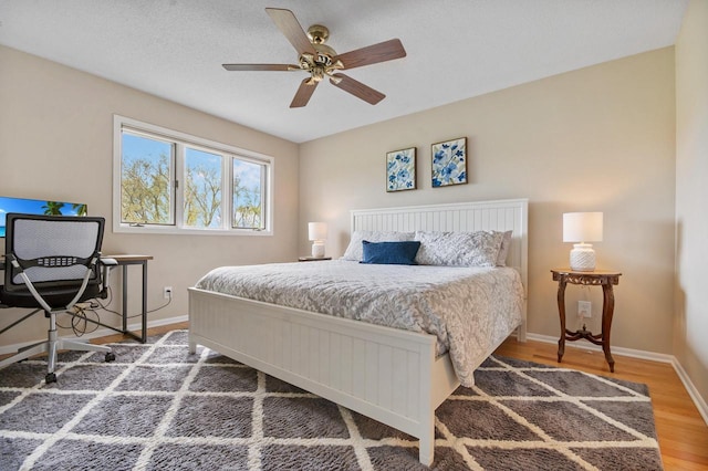 bedroom featuring baseboards, a ceiling fan, and wood finished floors