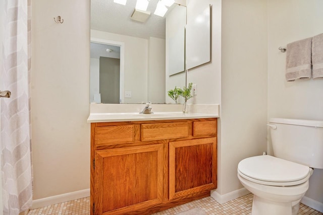 full bathroom featuring toilet, baseboards, and vanity