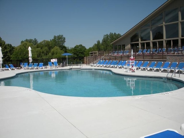 pool featuring fence and a patio area