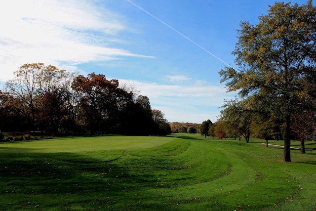 view of property's community with golf course view and a yard