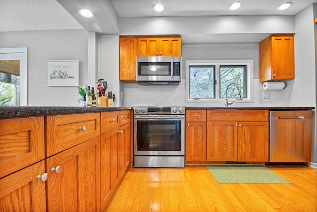 kitchen featuring brown cabinetry, stainless steel appliances, and backsplash