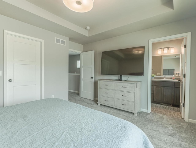 bedroom with connected bathroom, baseboards, visible vents, and light carpet