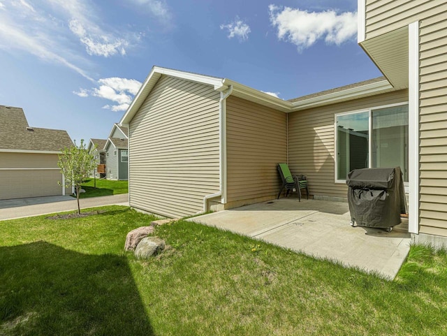 view of side of home featuring a lawn and a patio