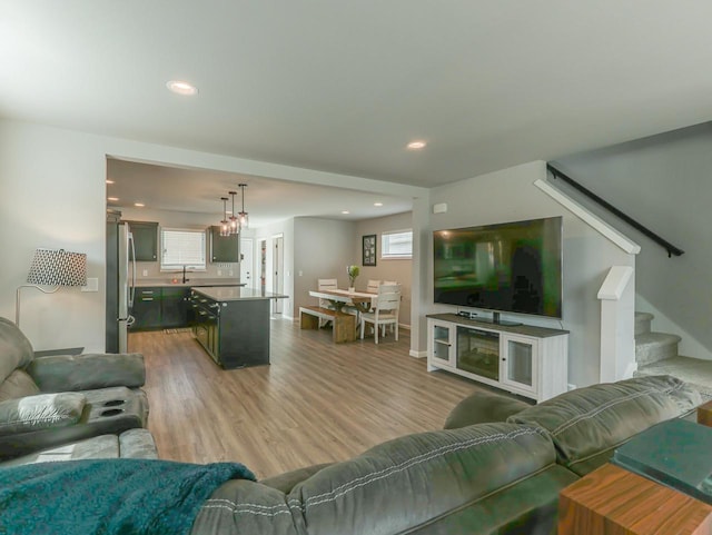 living area with recessed lighting, stairs, and wood finished floors
