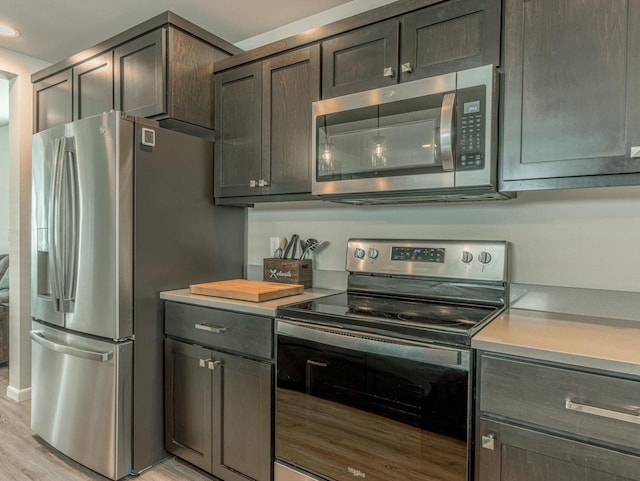 kitchen with light wood-style floors, light countertops, appliances with stainless steel finishes, and recessed lighting