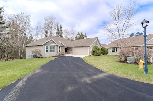 ranch-style home with stone siding, a garage, a front yard, a chimney, and driveway