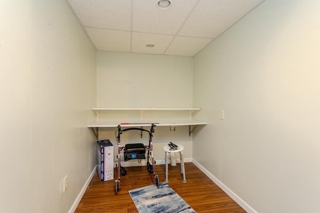 home office featuring baseboards, wood finished floors, and a paneled ceiling