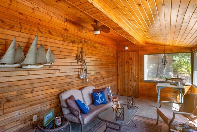 interior space featuring wood ceiling, a ceiling fan, carpet floors, lofted ceiling, and wooden walls