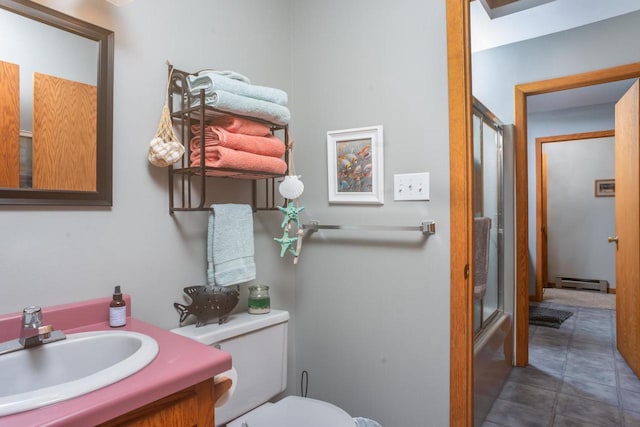 full bathroom with vanity, a baseboard heating unit, and toilet