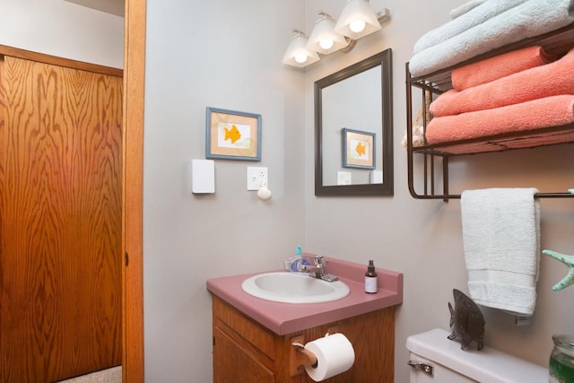 half bath featuring vanity and toilet