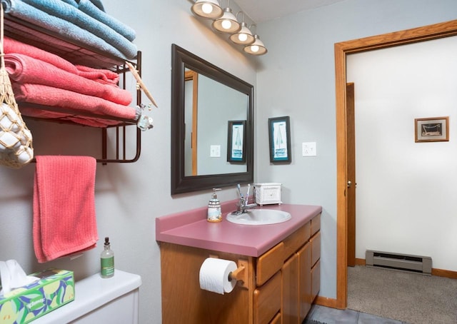 half bath featuring vanity, baseboards, a baseboard heating unit, and toilet