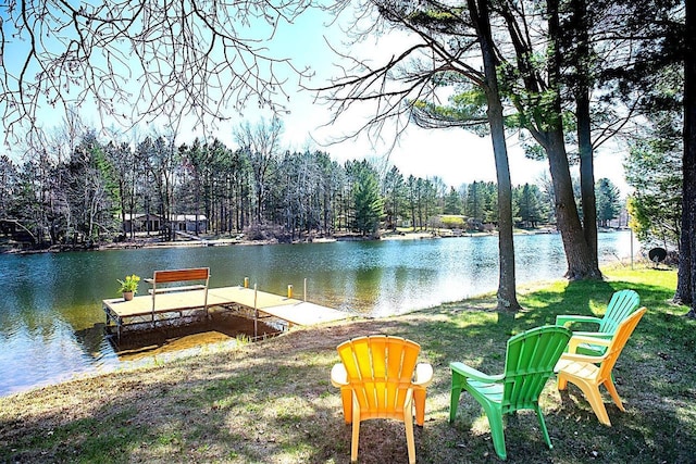 view of dock featuring a water view and a forest view