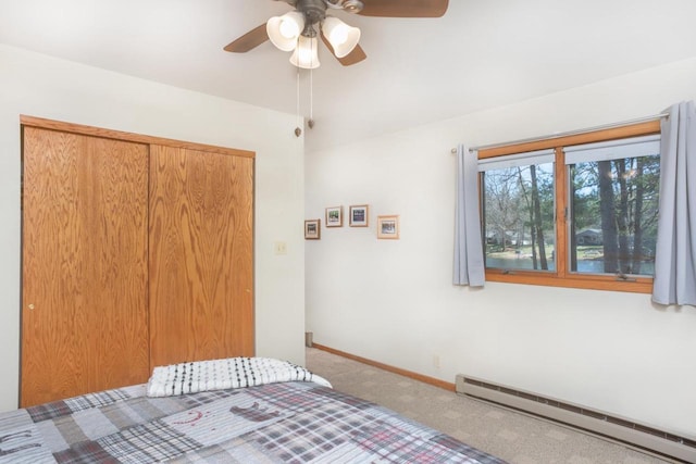 carpeted bedroom featuring baseboards, a baseboard radiator, a closet, and ceiling fan