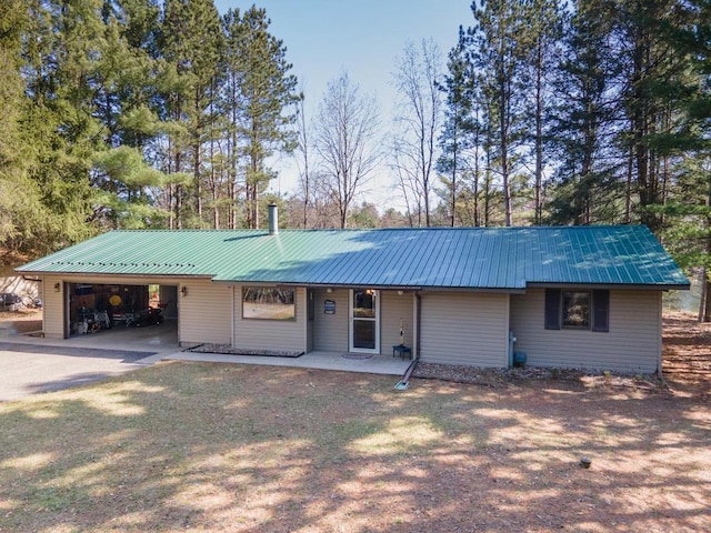 view of front of property featuring concrete driveway, a carport, covered porch, and metal roof