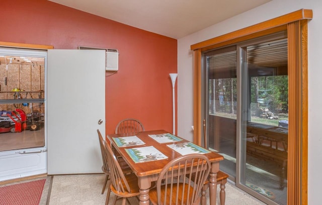dining room featuring vaulted ceiling, a wall unit AC, and carpet