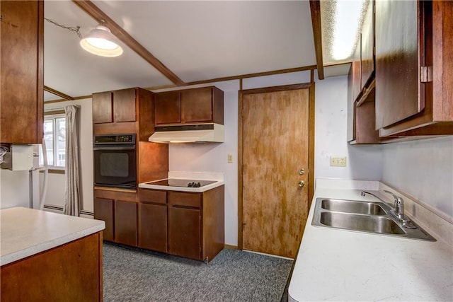 kitchen featuring brown cabinetry, light countertops, under cabinet range hood, a sink, and black appliances