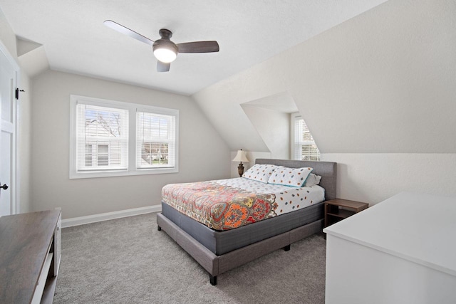 carpeted bedroom with ceiling fan and vaulted ceiling