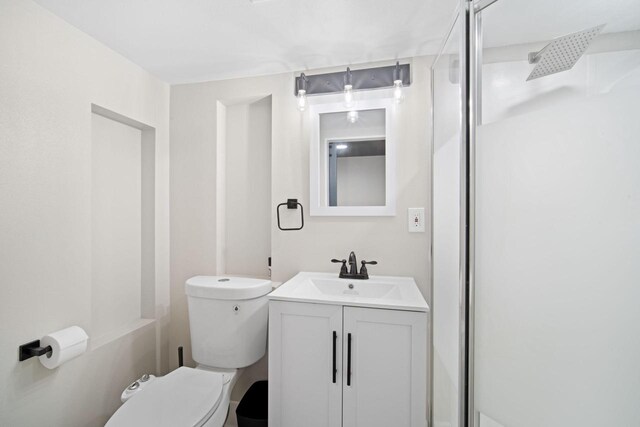 full bath featuring toilet, a shower stall, and vanity